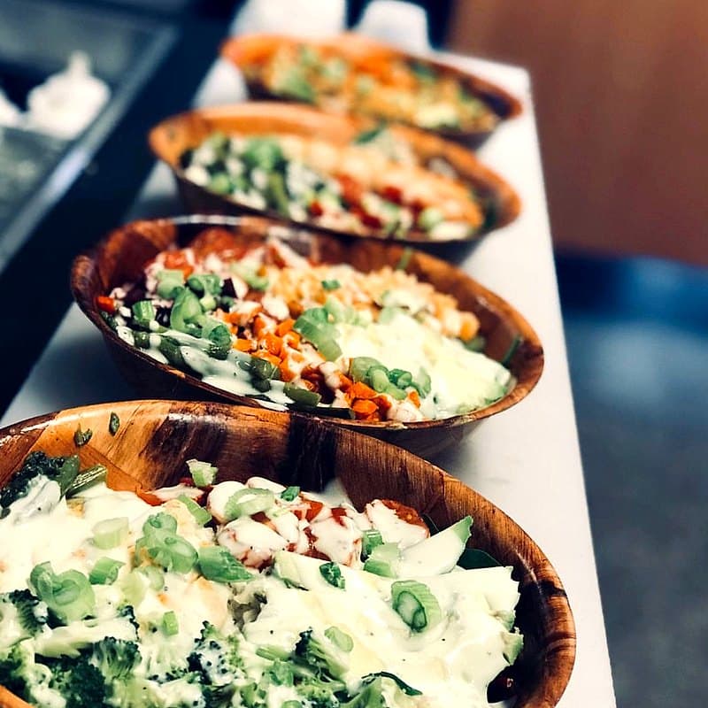Row of fresh prepared salad bowls
